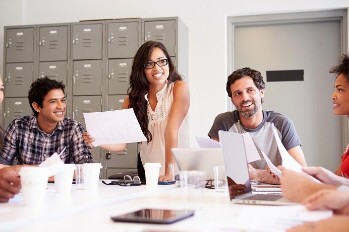 A group of people sitting around a table 
Description automatically generated with medium confidence